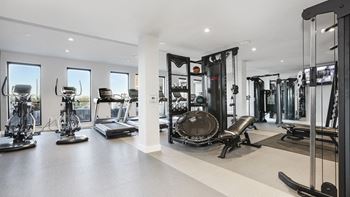 A spacious gym with a variety of equipment including treadmills, stationary bikes, and weight machines.